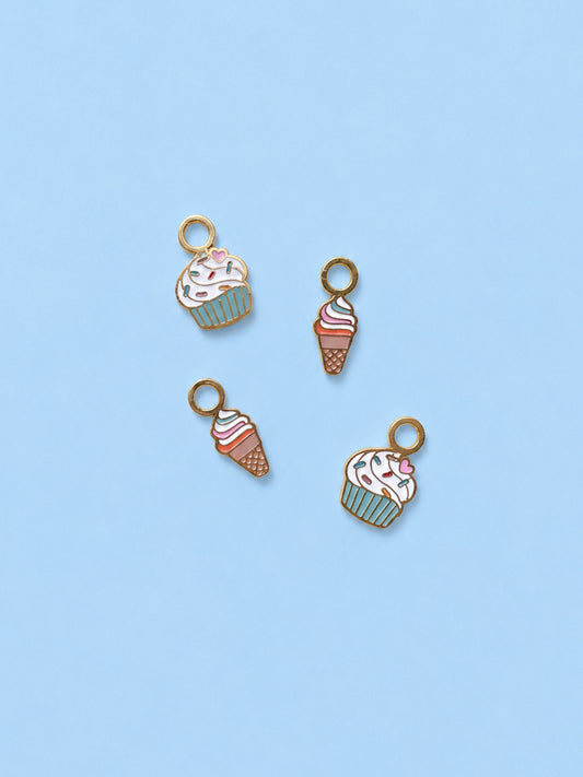 Four ice cream and cupcake charms on a light blue background