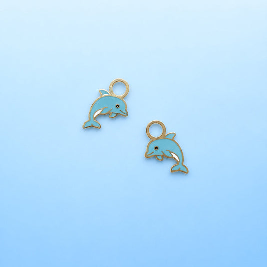 Two dolphin charms on a light blue background