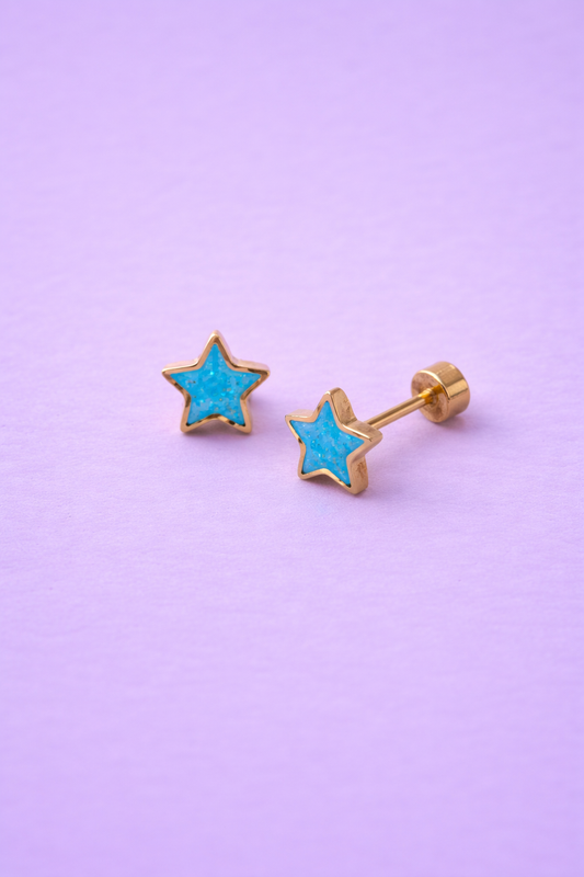 Star-shaped earrings with gold setting on a purple background