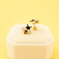 Bee-themed earrings on a white jewelry box with a yellow background