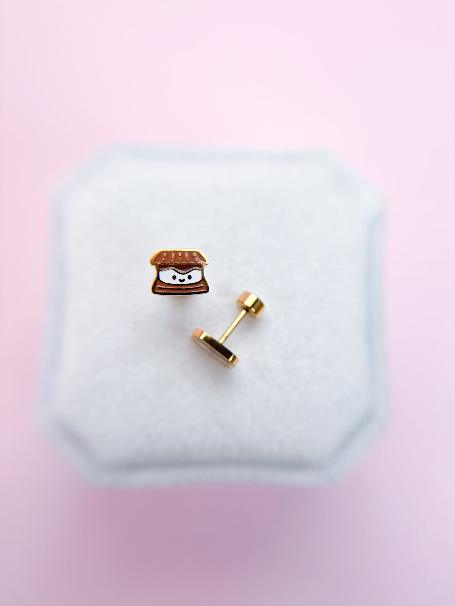 Smores stud earrings on white jewelry box with pink background 