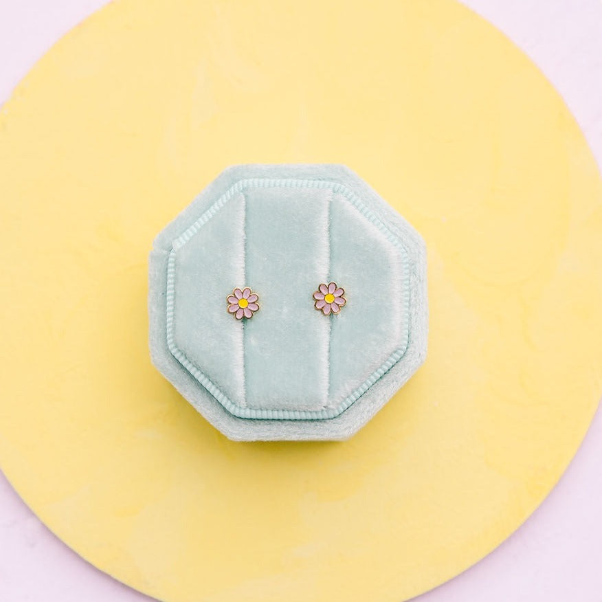 Lavender enamel daisy stud earrings in an Easter-themed display