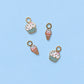 Four ice cream and cupcake charms on a light blue background