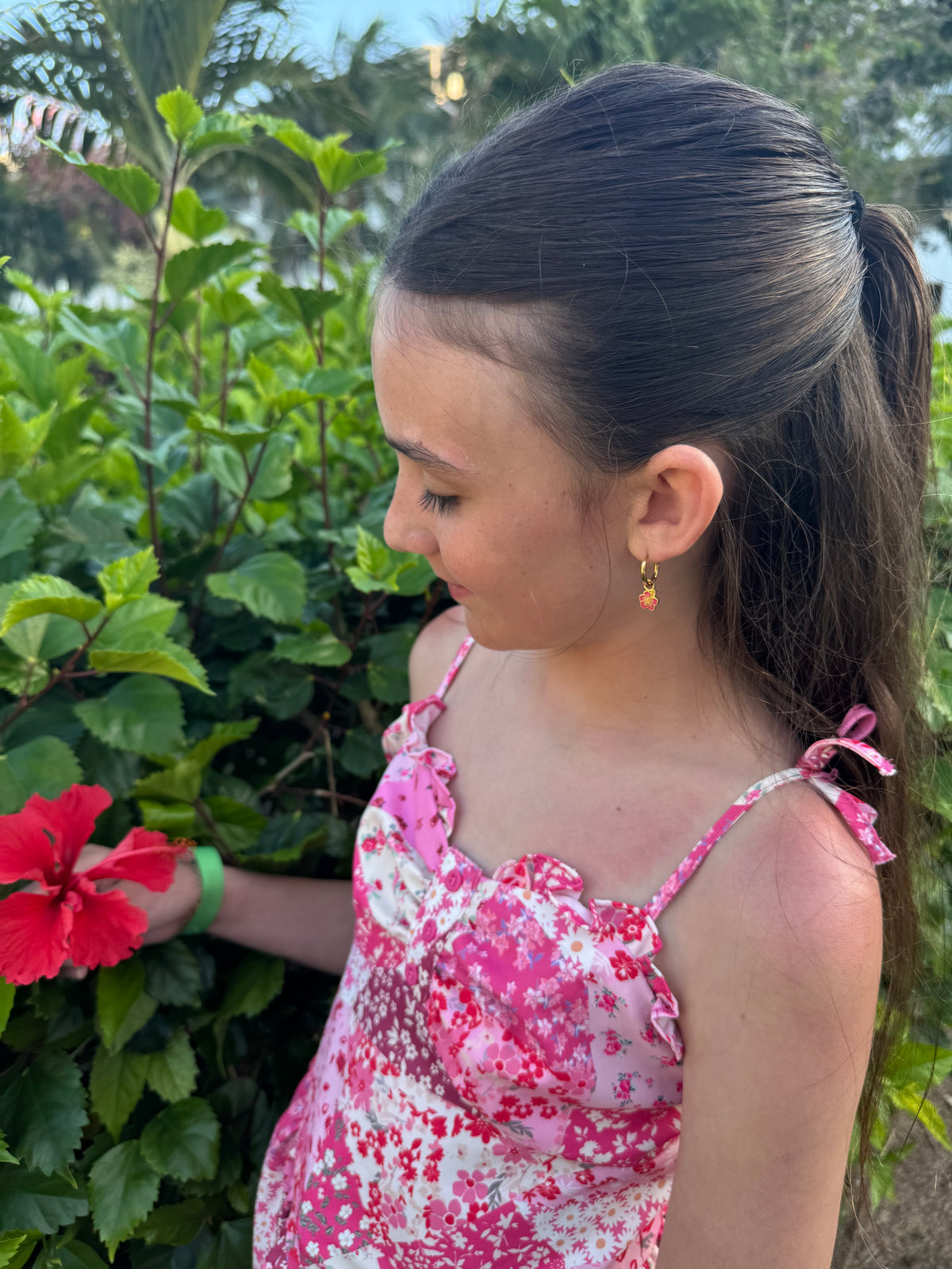 Hibiscus huggie charm worn on an ear