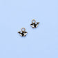 Two gold whale-shaped charms on a light blue background