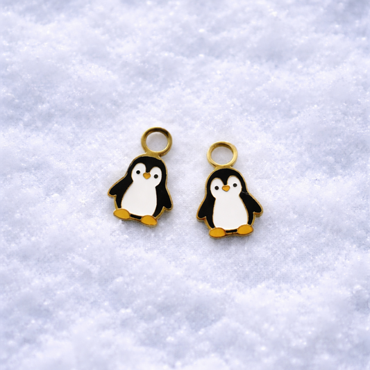 Two penguin charms on a textured white background