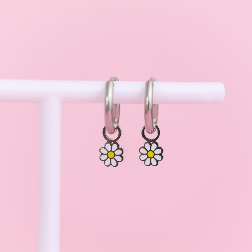 White daisy huggie charms on silver huggie hoops