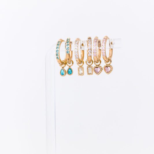 Set of gold hoop earrings with gemstones on a white background