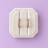 Lavender cz huggie hoops on a white jewelry box on a lavender background