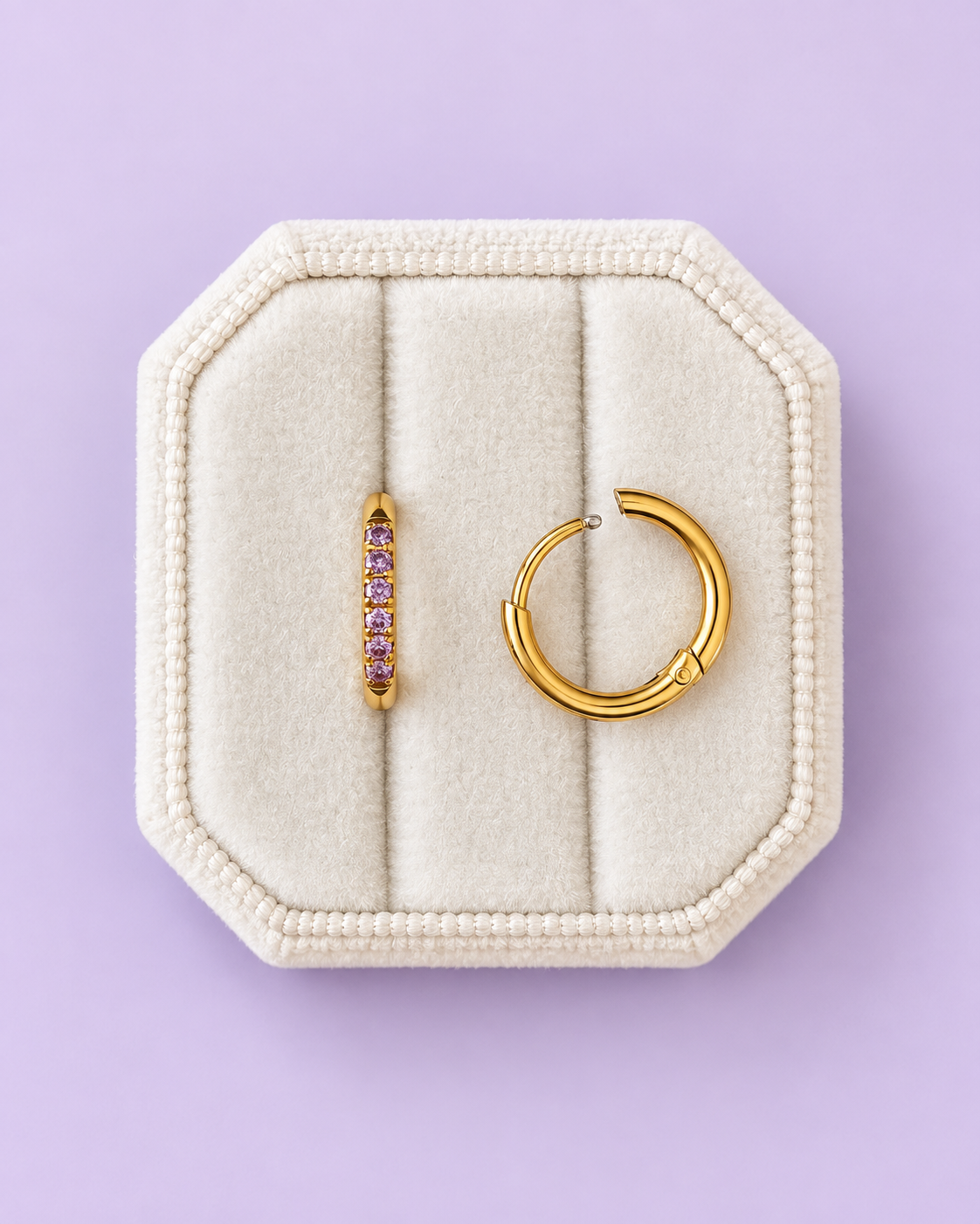 Lavender cz huggie hoops on a white jewelry box on a lavender background