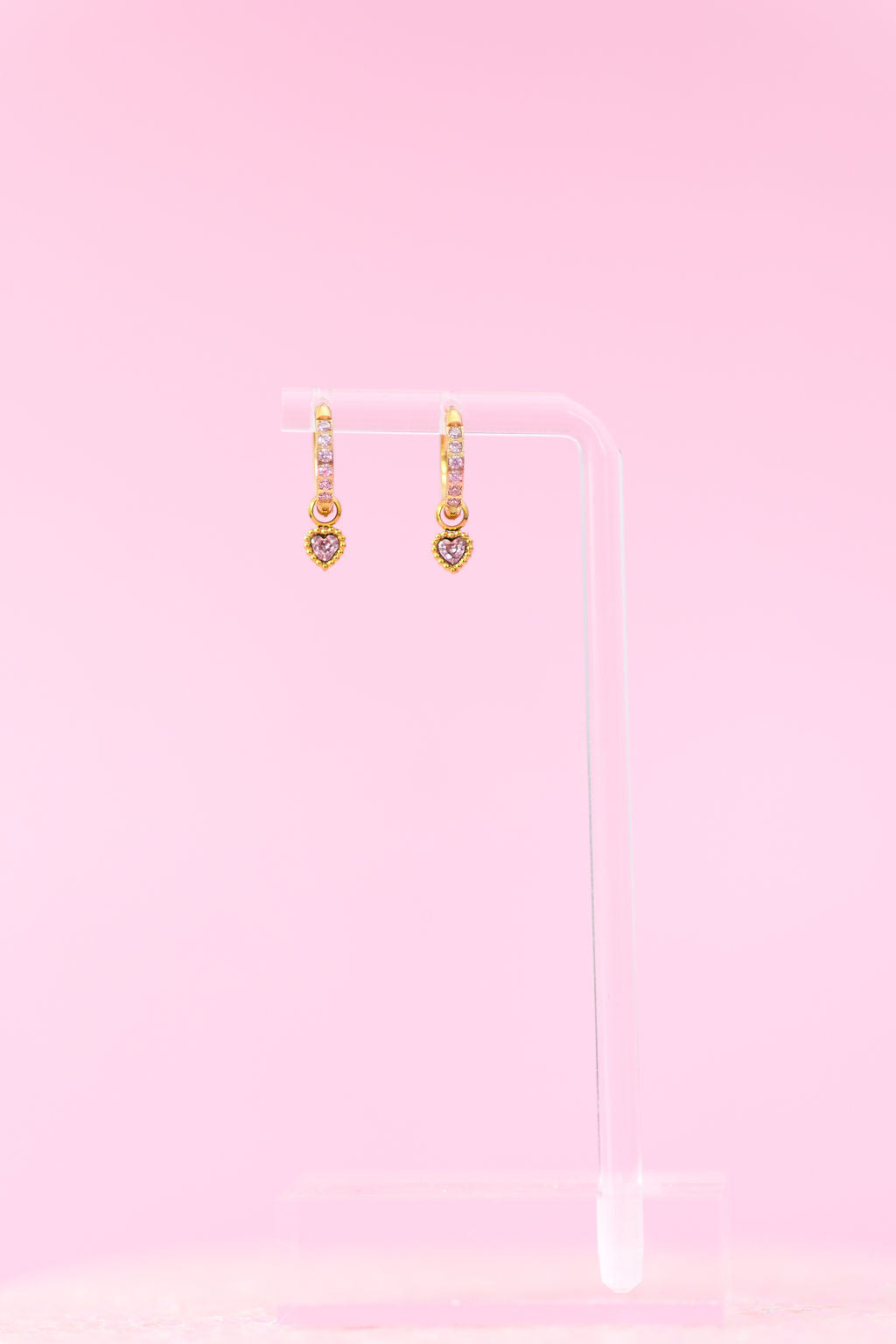 Pink heart gemstone huggie charms close-up