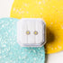 Pair of white enamel daisy stud earrings in gold-tone hypoallergenic stainless steel