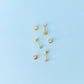 Gold earrings on a light blue background