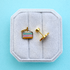 Birthday cake slice stud earrings on a white jewelry box on a light blue background