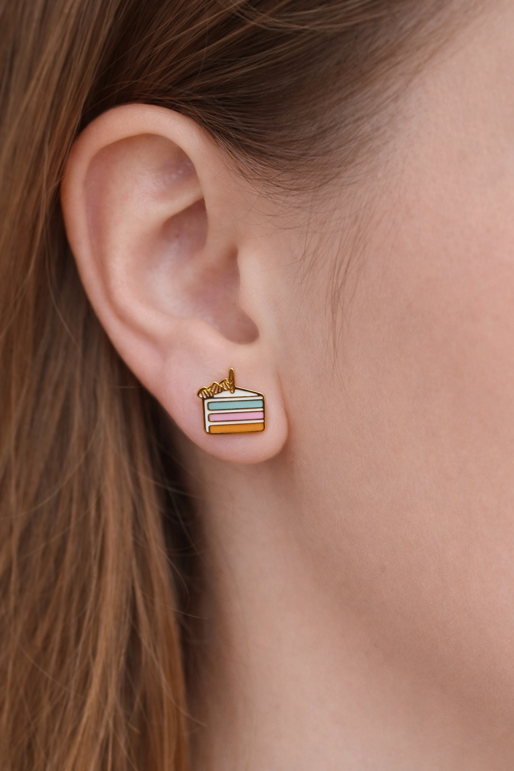 Birthday cake slice earring on a girl's ear