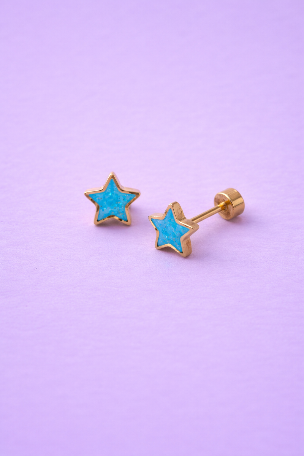 Sparkle Star Stud Earrings with gold setting and flat backs on a purple background