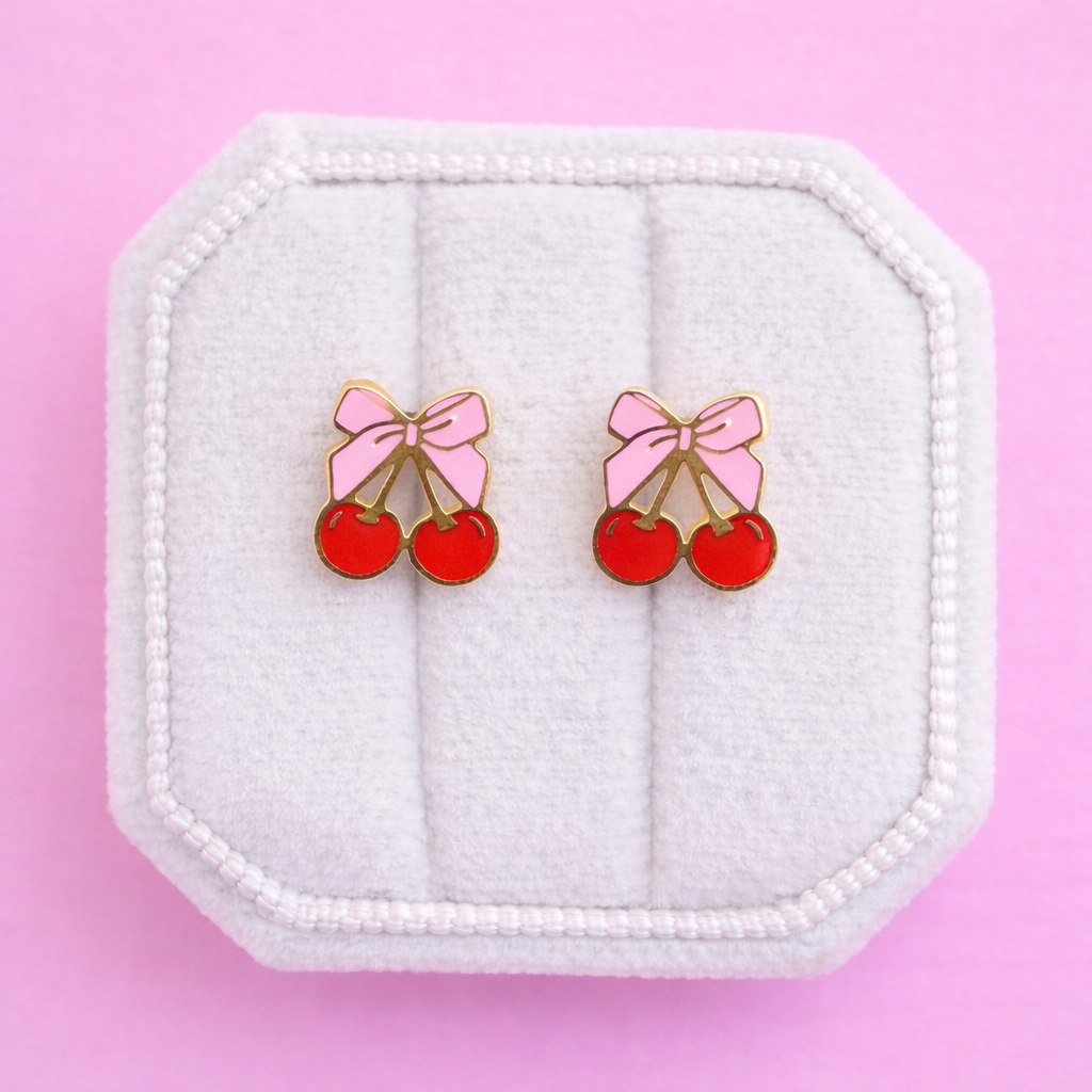 Bow Cherry Stud Earrings on a white jewelry box on a pink background