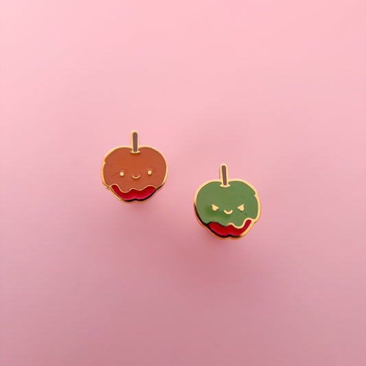 Two candy apple-shaped flat back stud earrings on a pink background