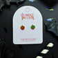 Desert Peach candy apple flat back stud earrings on a black background with decorative elements.