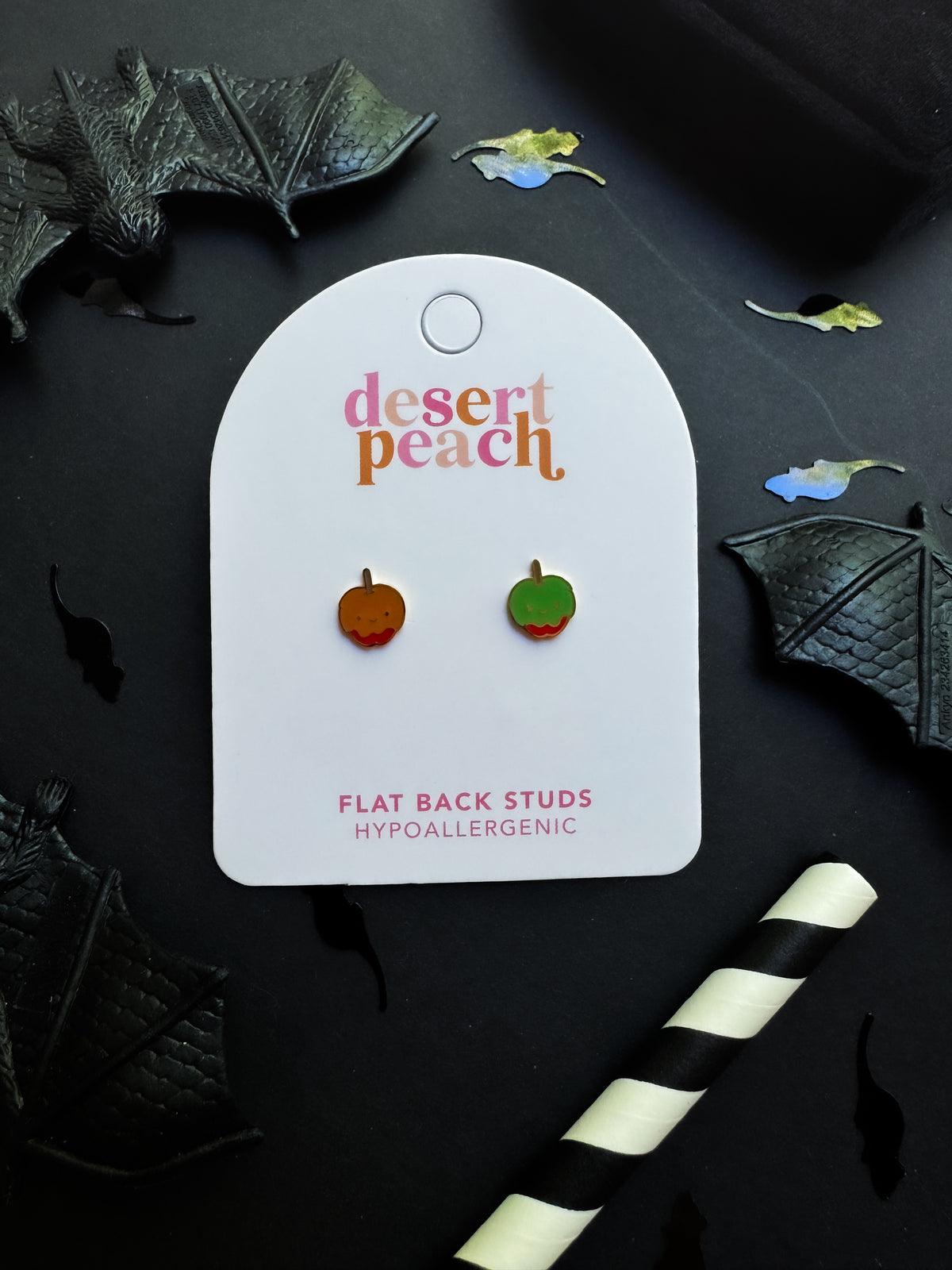 Desert Peach candy apple flat back stud earrings on a black background with decorative elements.