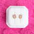 Disco balls with pink bows studs on a white jewelry box against a hot pink background