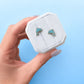 Hand holding a white jewelry box with blue dolphin designs against a light blue background