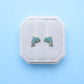 Dolphin earrings in a white box on a light blue background