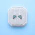 Dolphin earrings in a white box on a light blue background