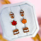 Set of autumn-themed earrings on a white square background