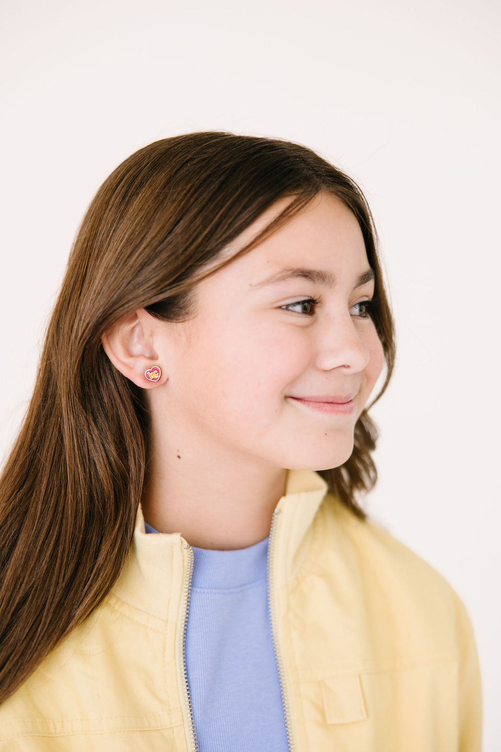 KC heart stud earring worn on an ear