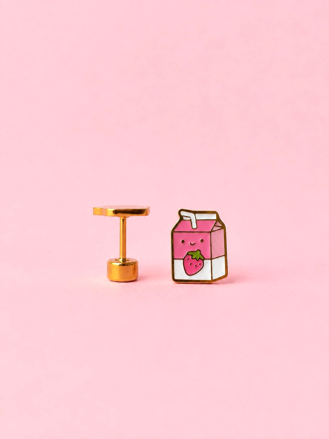 Two milk carton shaped stud earrings. One chocolate, one strawberry on a light pink background