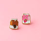 Two milk carton shaped stud earrings. One chocolate, one strawberry on a light pink background