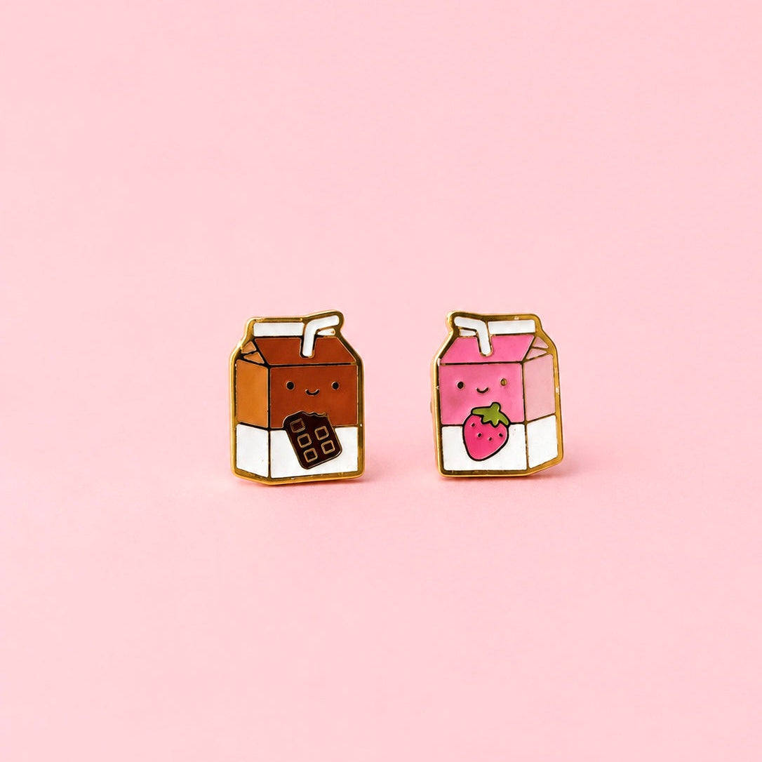 Two milk carton shaped stud earrings. One chocolate, one strawberry on a light pink background