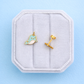 narwhal studs on a white jewelry bow on a blue background