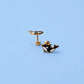 Black and gold whale-shaped earrings on a light blue background