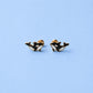 Pair of orca whale earrings on a light blue background
