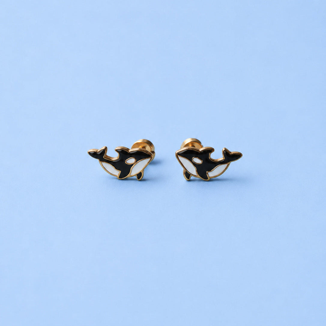 Pair of orca whale earrings on a light blue background