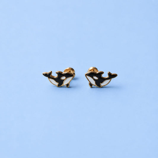 Pair of orca whale earrings on a light blue background