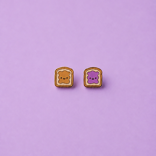 Peanut butter and jelly shaped enamel stud earrings on a light purple background