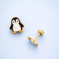 Penguin-shaped earrings on a light blue background