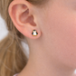 Penguin-shaped earrings worn by a person with blonde hair.