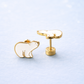 Gold and white bear-shaped earrings on a light blue background