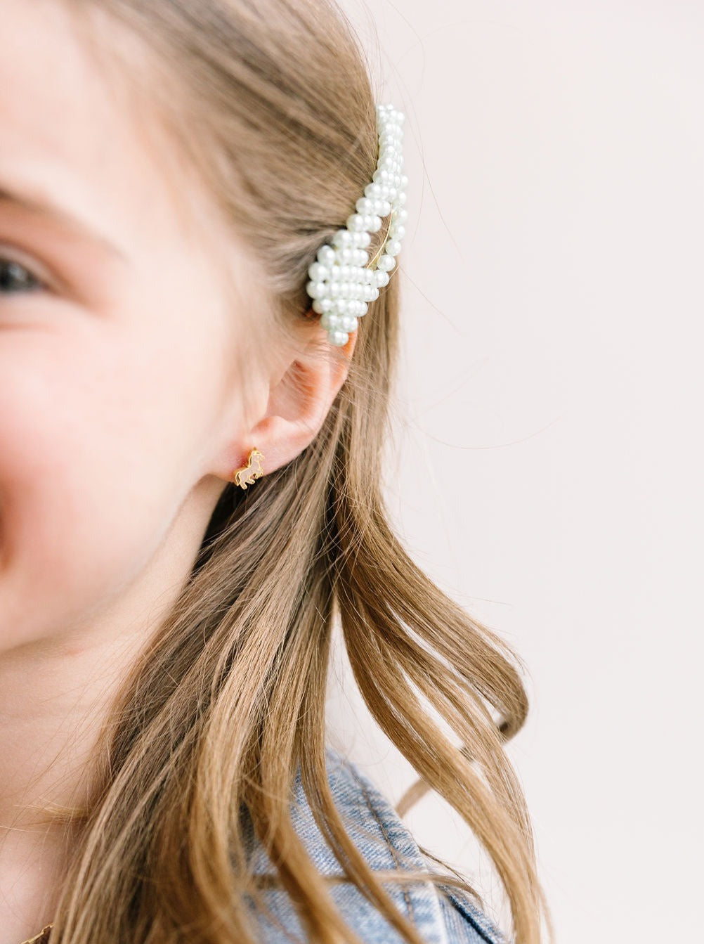 Pony stud earring worn on an ear