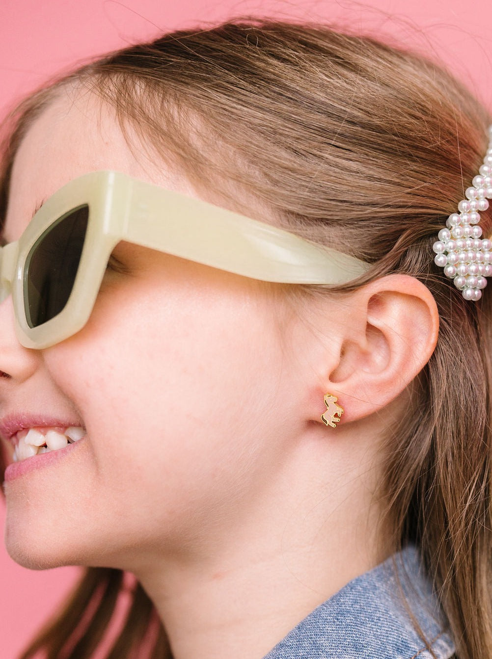 Pony stud earring worn on an ear, close-up