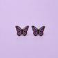Pair of purple enamel butterfly earrings on a light purple background