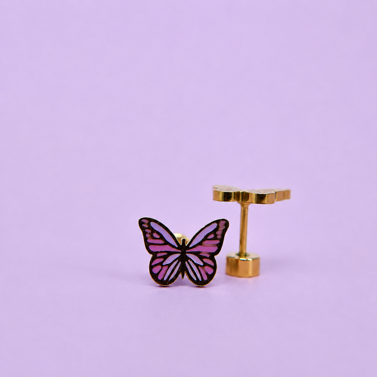 Pair of purple enamel butterfly earrings on a light purple background