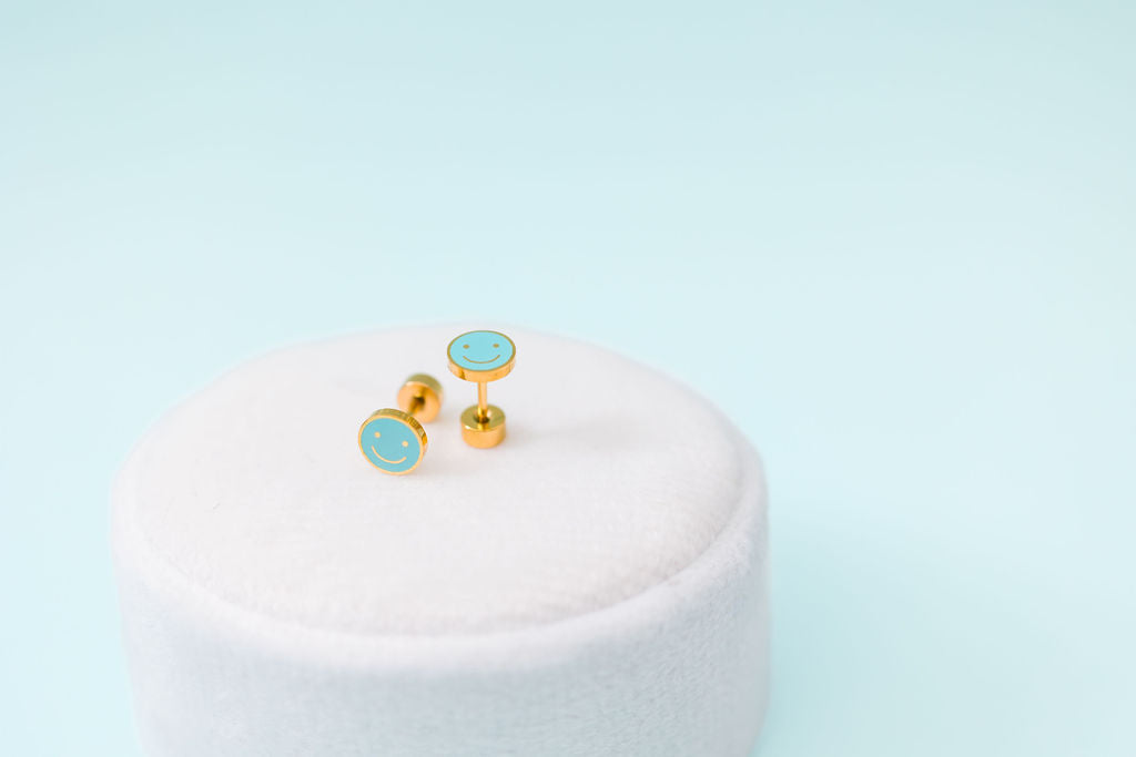 Blue smiley face stud earrings close-up