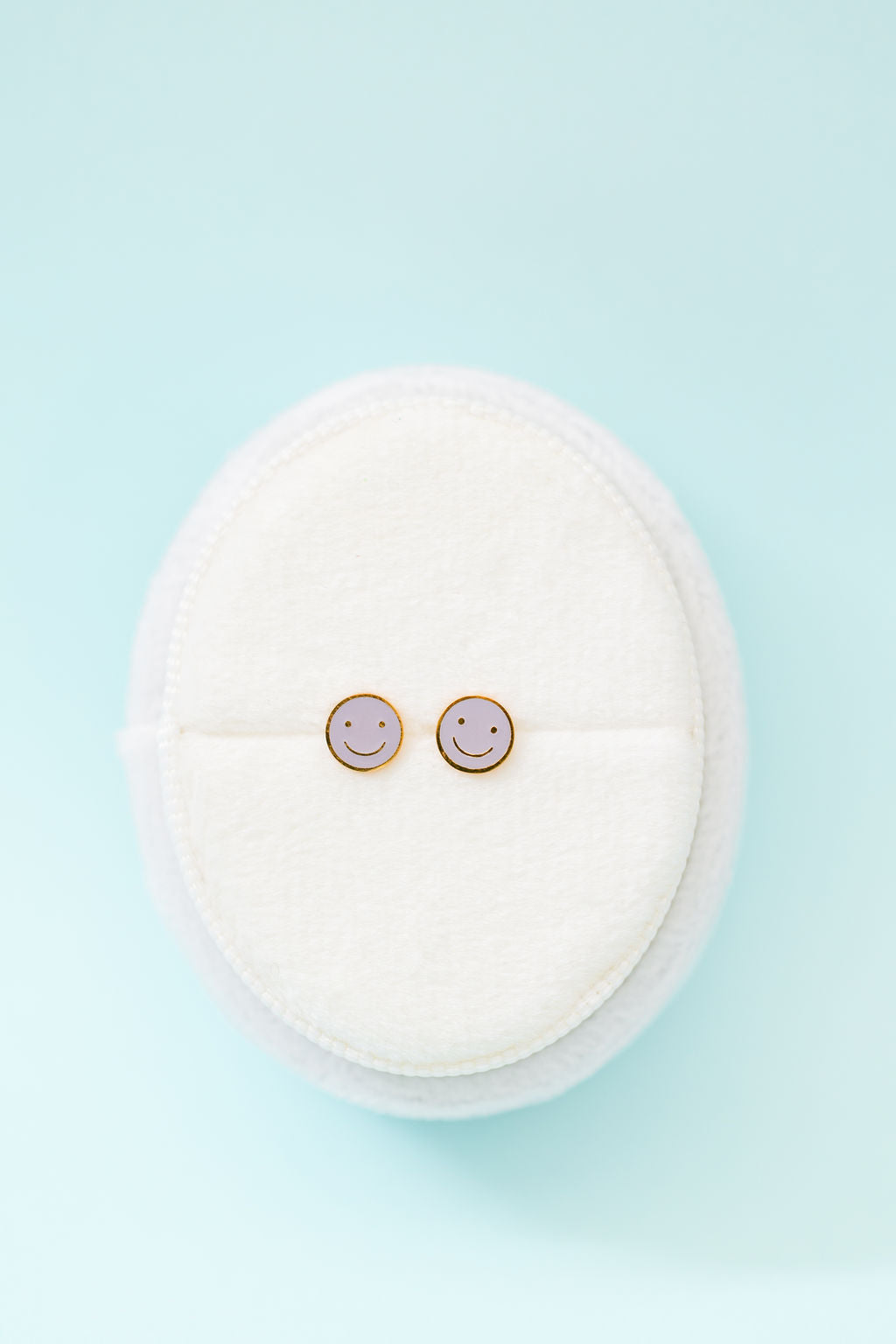 Lavender smiley face stud earrings close-up