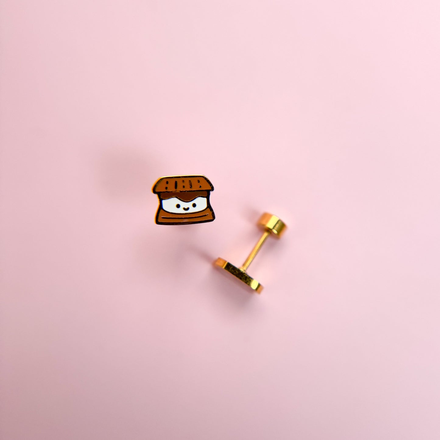 Kawaii s'mores-shaped earrings on a pink background