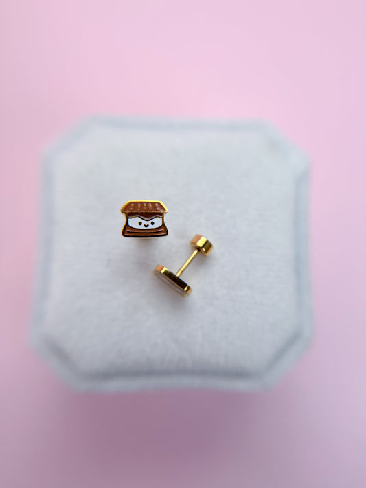 Kawaii s'mored shaped earring on a white cushion with a pink background